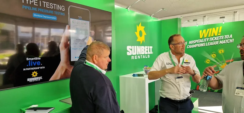 Industry specialists demonstrating digital test equipment at an exhibition